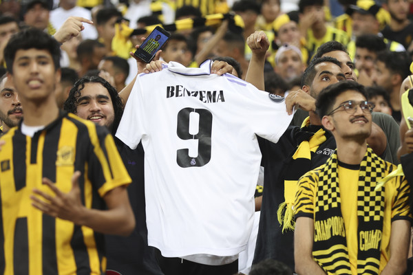 사우디아라비아 제다의 킹 압둘라 스포츠 시티 스타디움에서 열린 카림 벤제마 입단식에서 현지팬들이 벤제마 이름이 새긴 레알마드리드 유니폼을 흔들며 환영하고 있다. ⓒ뉴시스
